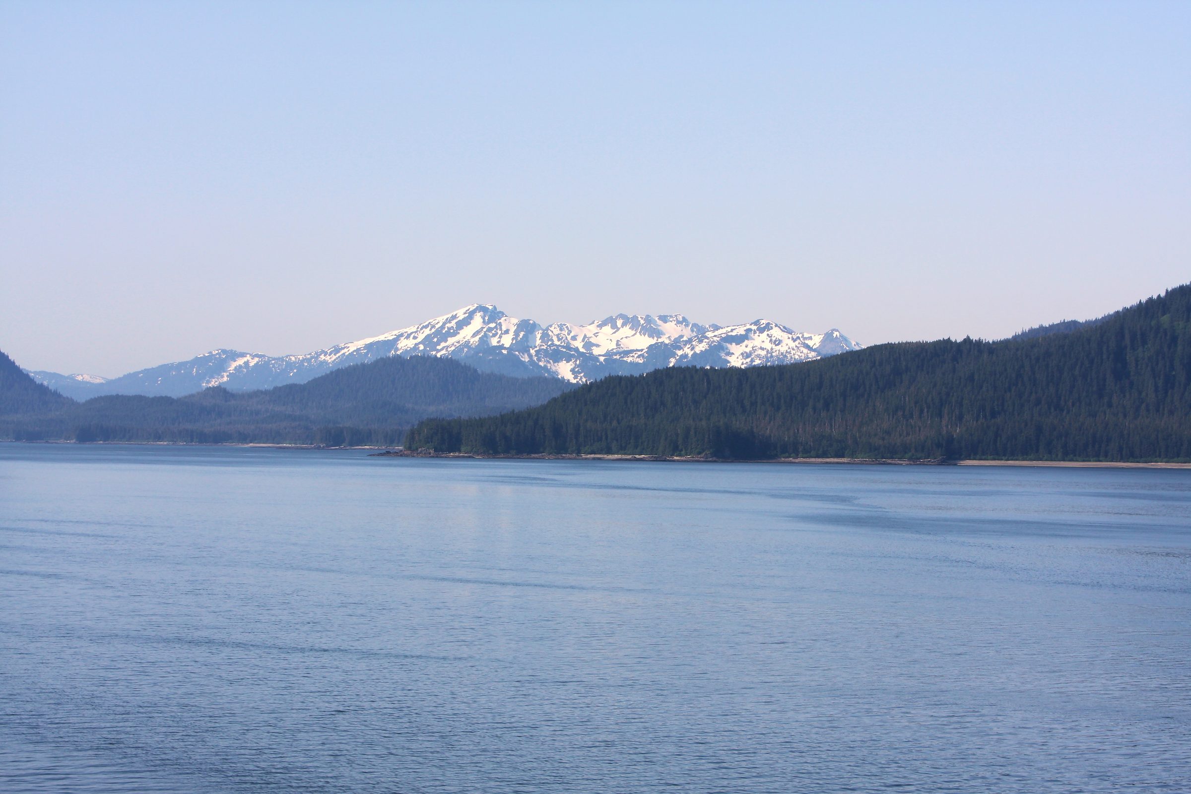 Snow-dusted mountains ringing a long blue fjord or lake.