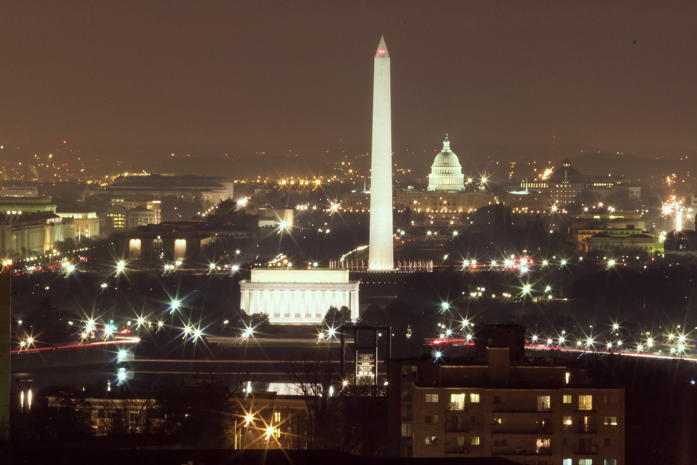 Washington Monument and Capitol dome lit at night across the city.