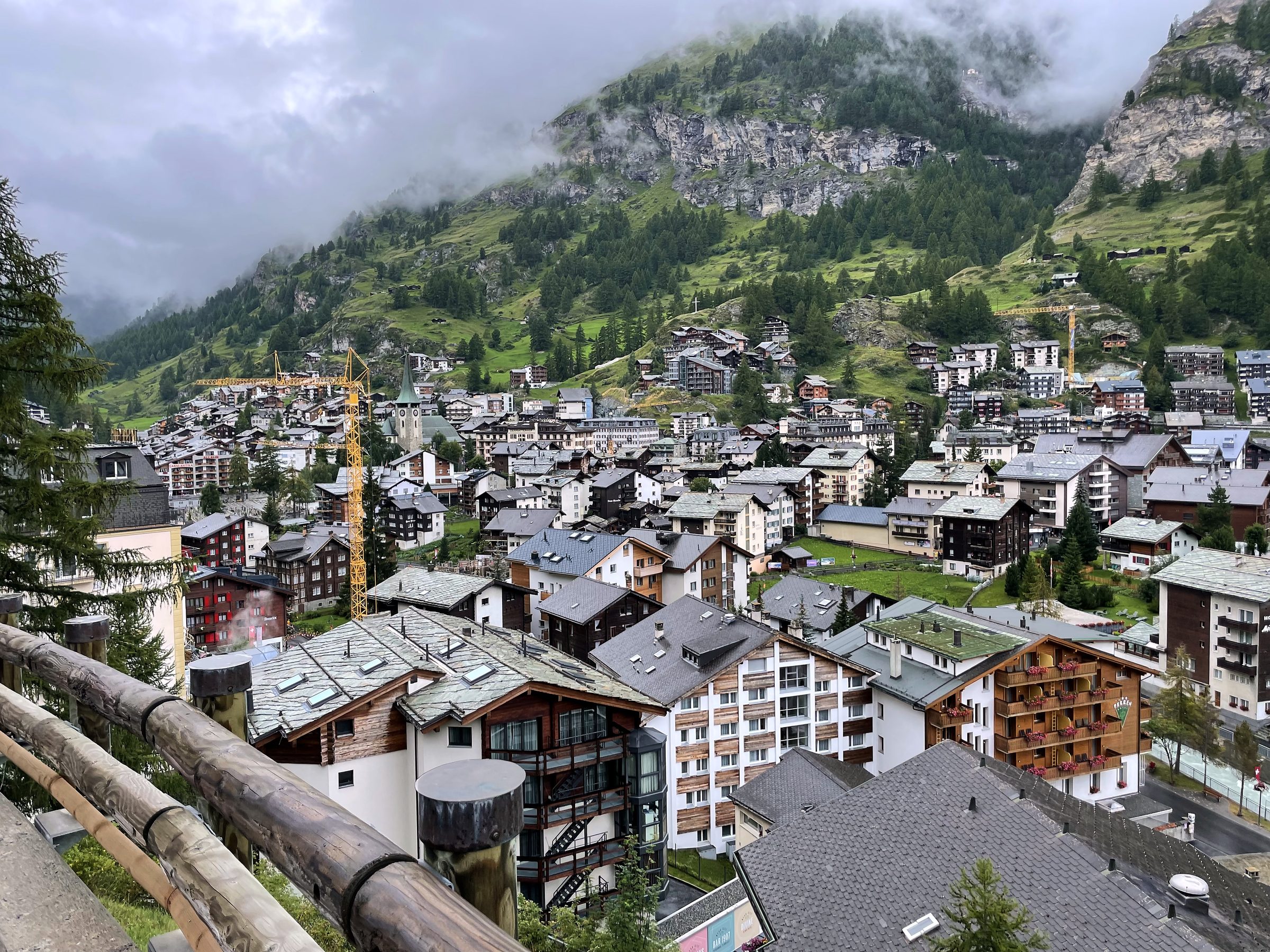 Alpine village chalets nestled in a valley under mist.