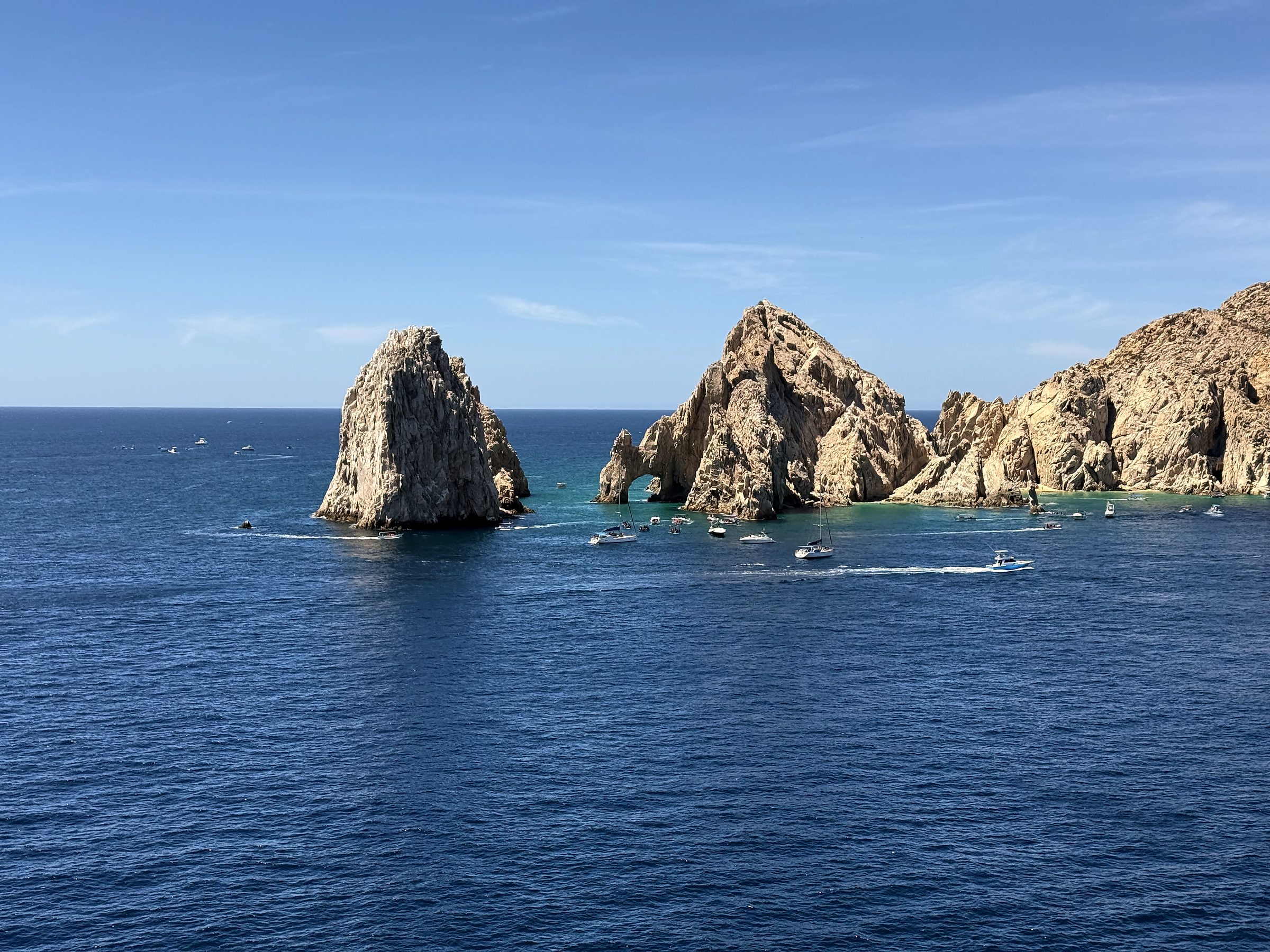 Arch and pillar sea stacks in deep sapphire water.