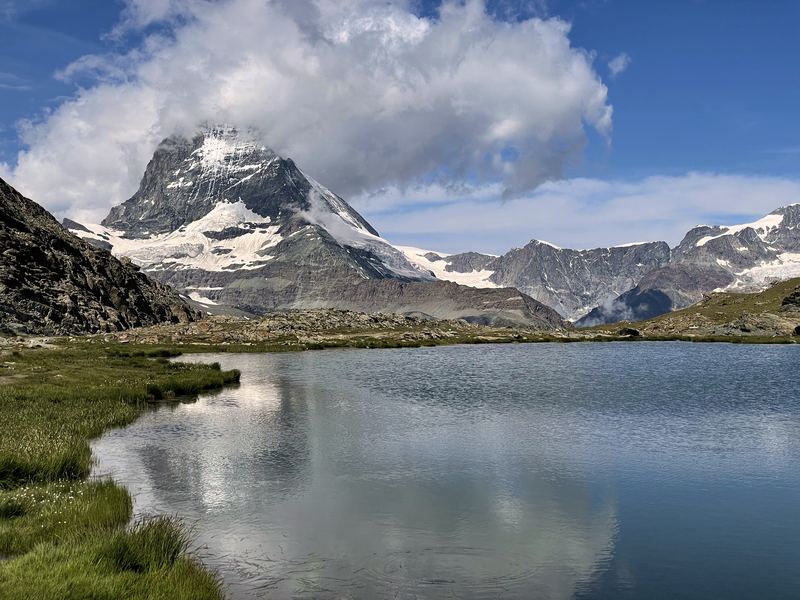 Matterhorn perfectly mirrored in still alpine lake water.