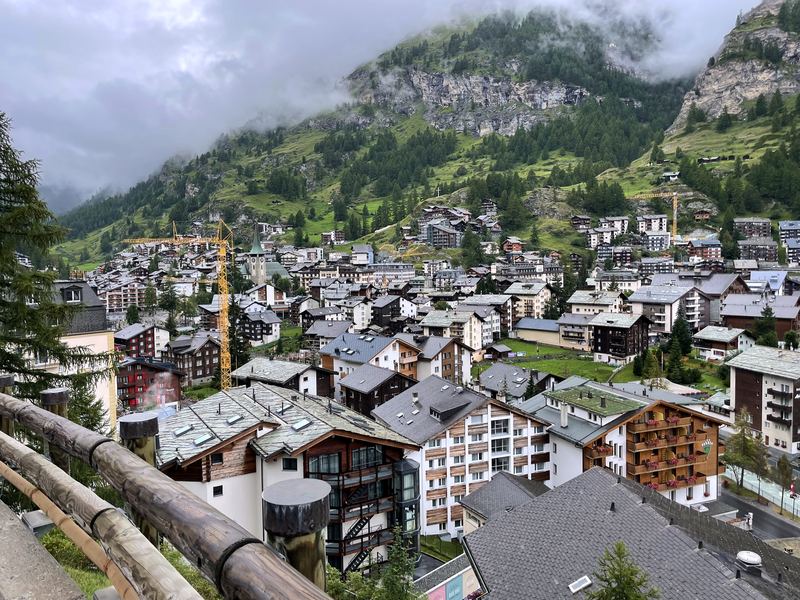 Alpine village chalets nestled in a valley under mist.