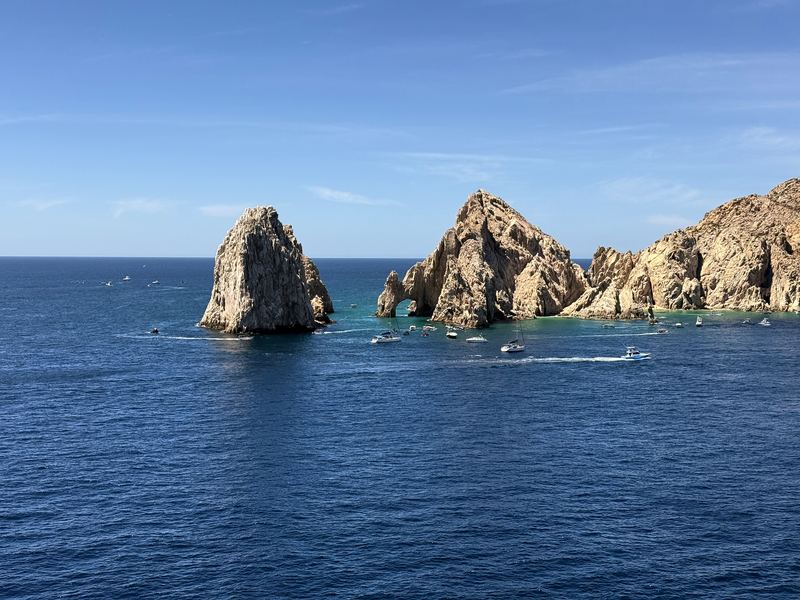 Arch and pillar sea stacks in deep sapphire water.