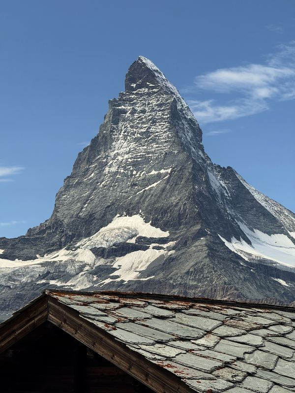 Matterhorn rising over the edge of a stone-shingled alpine roof.
